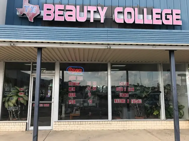Front exterior of Texas Beauty College, showing the large pink TEXAS BEAUTY COLLEGE sign above the covered storefront and glass entrance.