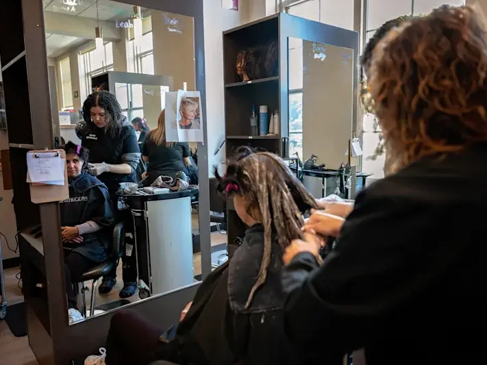 Students working with clients in Durfee High School's cosmetology salon