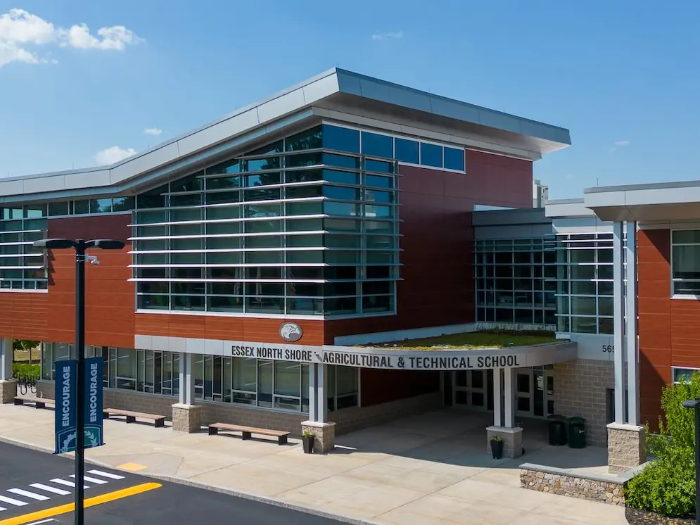 Exterior of Essex North Shore Agricultural & Technical School, a modern brick-and-glass building with the school name displayed above the entrance.
