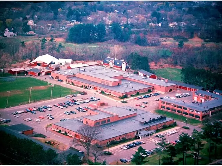 Aerial view of the Smith Vocational and Agricultural High School campus, showing several school buildings, parking lots, athletic fields, and surrounding wooded hills.