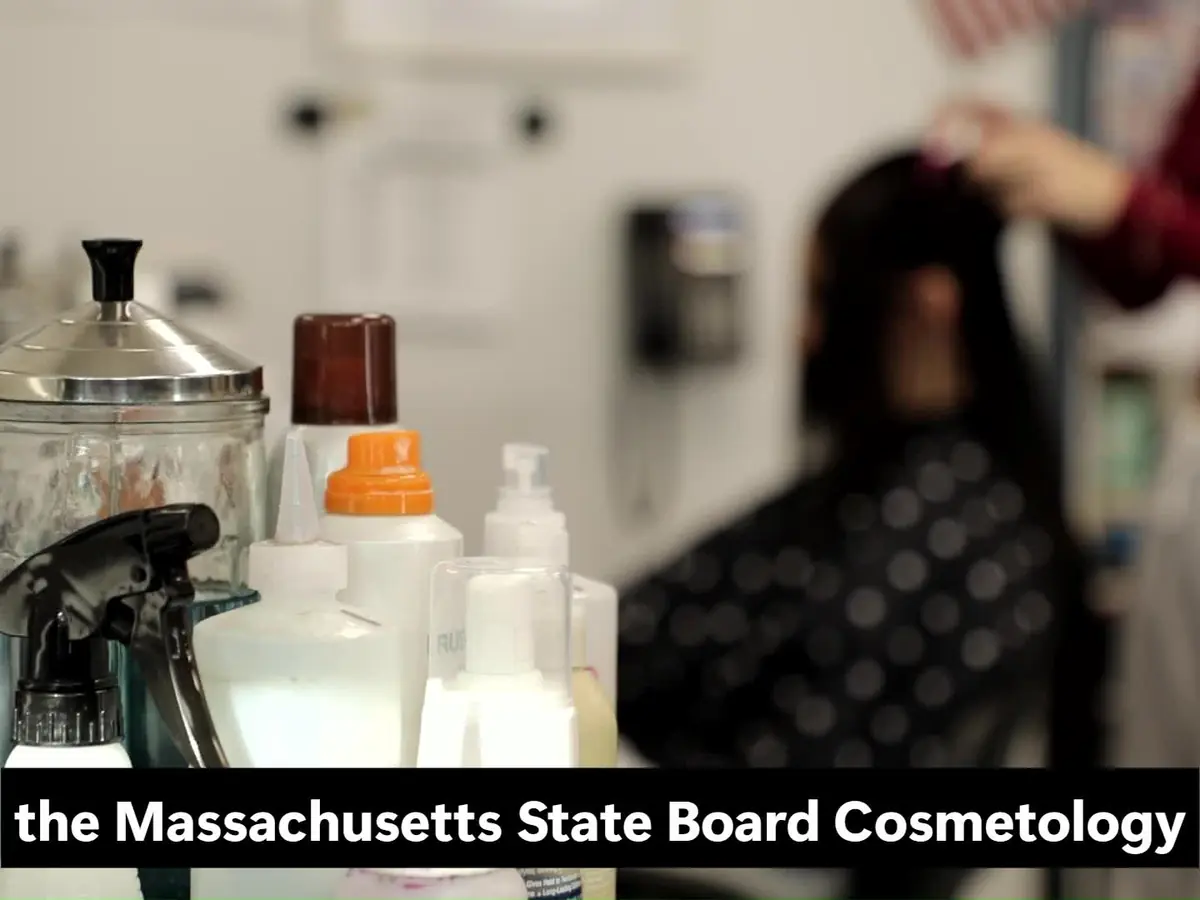 Cosmetology students work with a seated client in a salon, with hair-care bottles and equipment in the foreground.