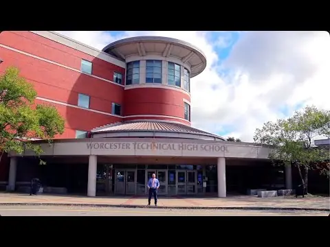 Front entrance of Worcester Technical High School, a red-brick building with a rounded upper section and the school name displayed above the doors.