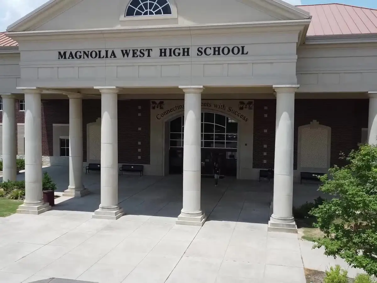 Front entrance of Magnolia West High School, with white columns and the school name displayed above the main doors.