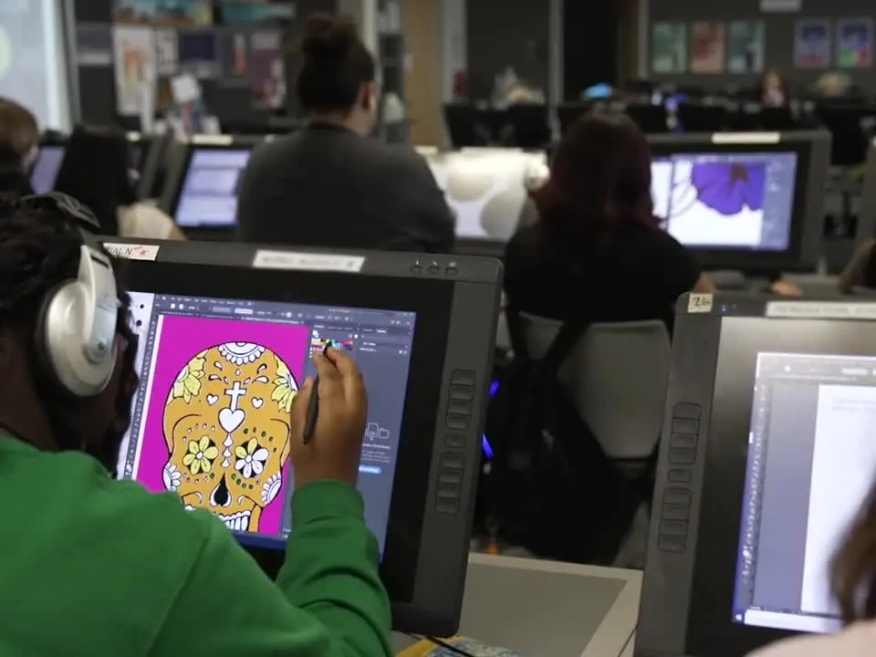 Students work at desktop computers in a TECC-E digital arts classroom.