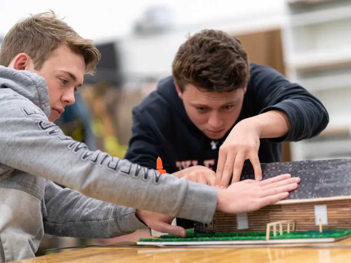 Two students work together on a detailed architectural model on a classroom table at the Tyler ISD Career & Technology Center.