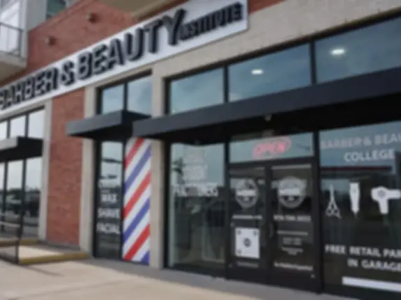 Exterior storefront of Modern Barber & Beauty Institute in a brick commercial building, with large institute signage, a barber pole by the glass entrance, and windows displaying barber and beauty graphics.
