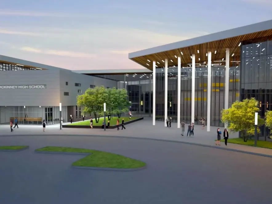Wide exterior view of McKinney High School, showing modern glass-fronted buildings, a covered entrance, paved courtyard, lawns, and small figures of students.
