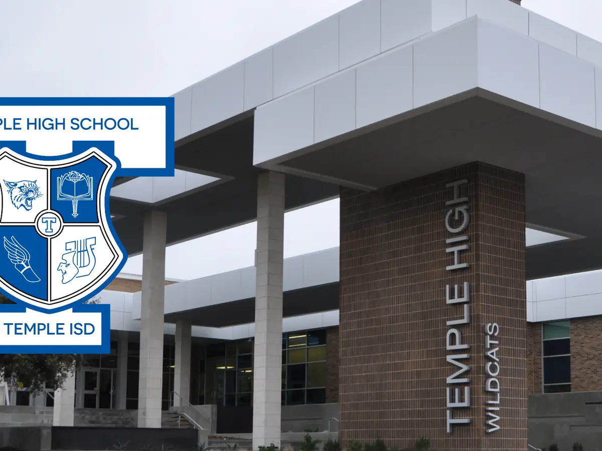 Front entrance of Temple High School, showing white columns, a covered entryway, the Temple High Wildcats sign on a brick pillar, and the school crest graphic at left.
