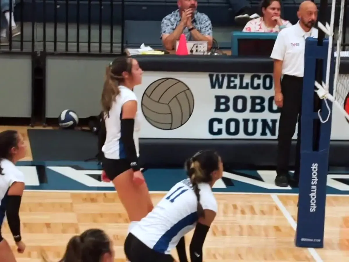 South San Antonio High School volleyball players competing in a gym beneath a Welcome Bobcats sign.