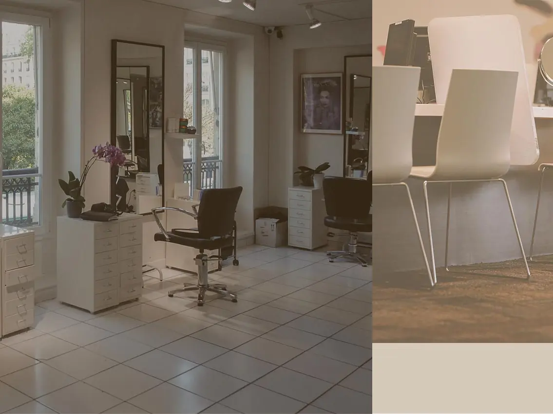 Bright beauty salon interior with styling chairs, mirrors, salon workstations, and large windows opening toward a balcony.