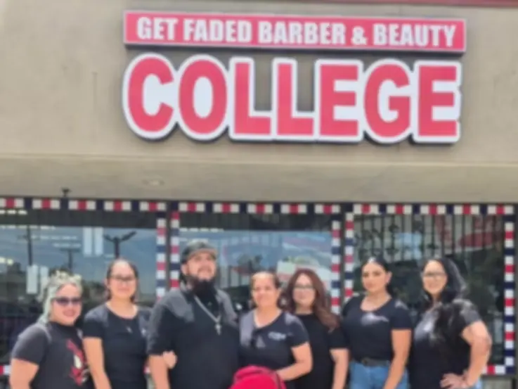 Group of people standing outside Get Faded Barber & Beauty College beneath the college's large pink-and-white sign.